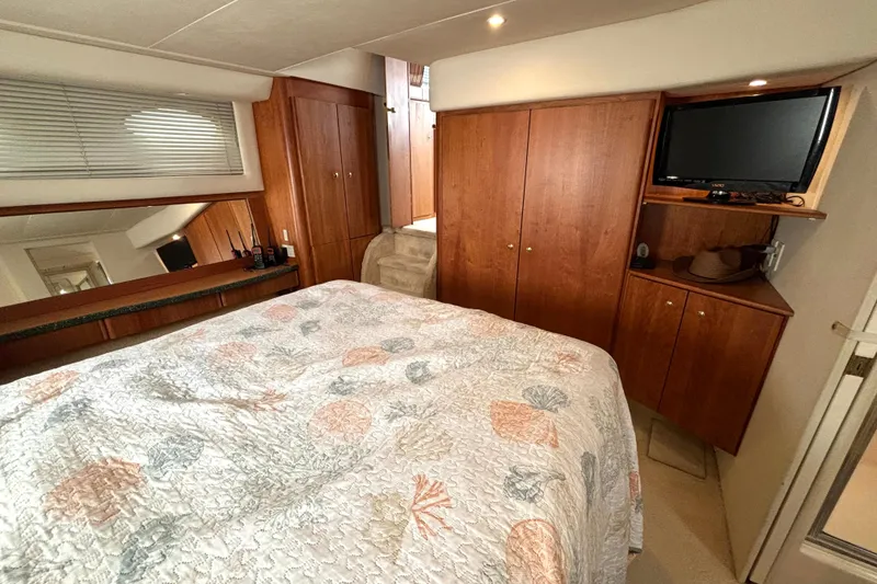 Slide: The Image of Cozy bedroom in 2000 Silverton 422 Motor Yacht with wood cabinetry and TV. - 44