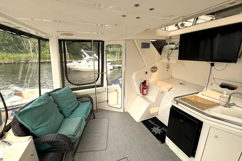 Slide: The Image of Interior of 2000 Silverton 422 Motor Yacht with seating, kitchenette, and waterfront view. - 16