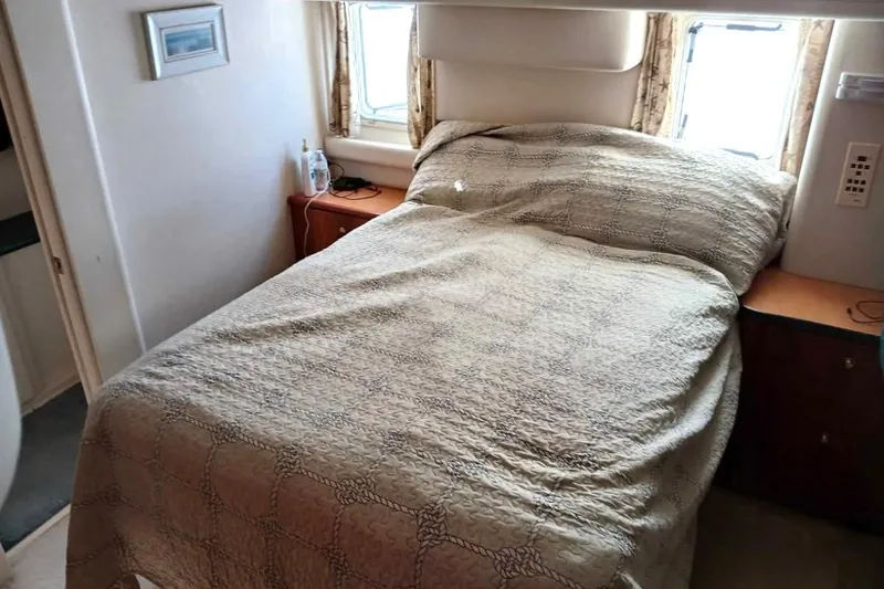 Slide: The Image of Cozy bedroom interior of 2000 Silverton 422 Motor Yacht with bed and window view. - 9