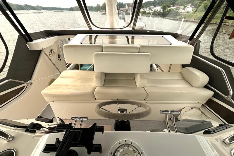 Slide: The Image of Interior view of 2000 Silverton 422 Motor Yacht helm with plush seating and steering wheel. - 28