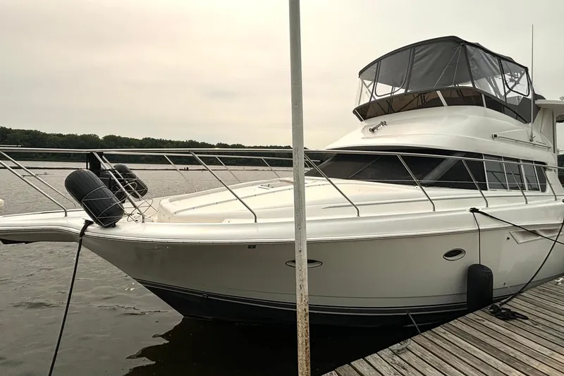 Slide: The Image of 2000 Silverton 422 Motor Yacht docked by the water on a cloudy day. - 3