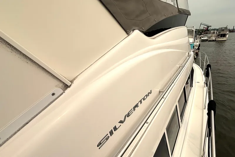 Slide: The Image of 2000 Silverton 422 Motor Yacht docked, showcasing sleek design and branding. - 8