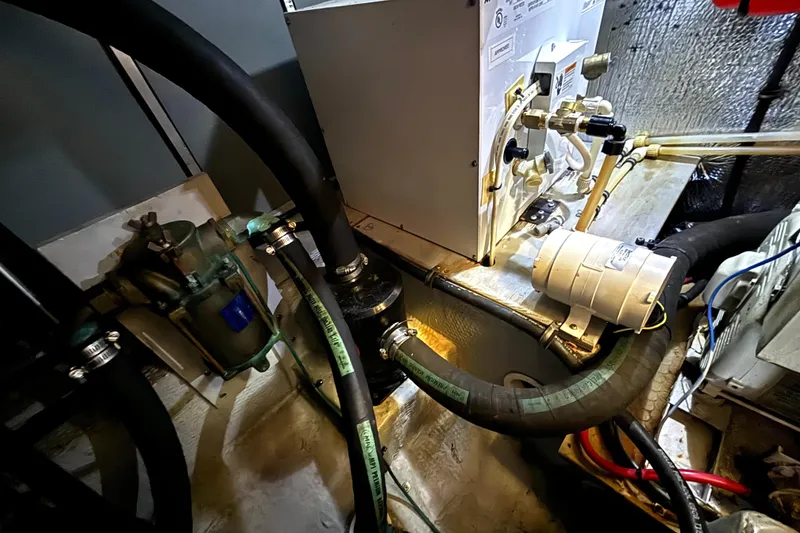 Slide: The Image of Engine room of a 2000 Silverton 422 Motor Yacht with visible hoses and machinery. - 57