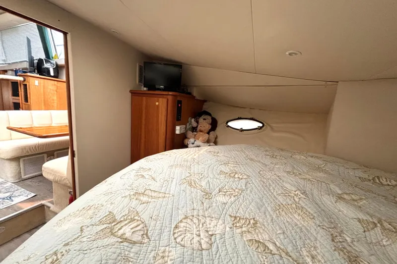 Slide: The Image of Cozy bedroom in 2000 Silverton 422 Motor Yacht with nautical-themed bedding and porthole window. - 40