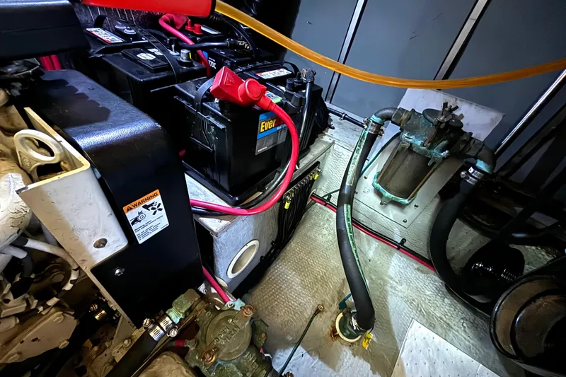 Slide: The Image of Engine room of a 2000 Silverton 422 Motor Yacht with batteries and hoses visible. - 56