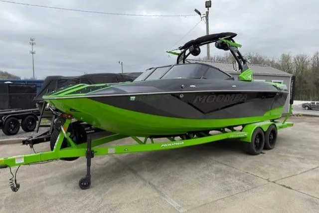 The Image of 2022 Moomba Makai boat in vibrant green and black on a trailer. - 0