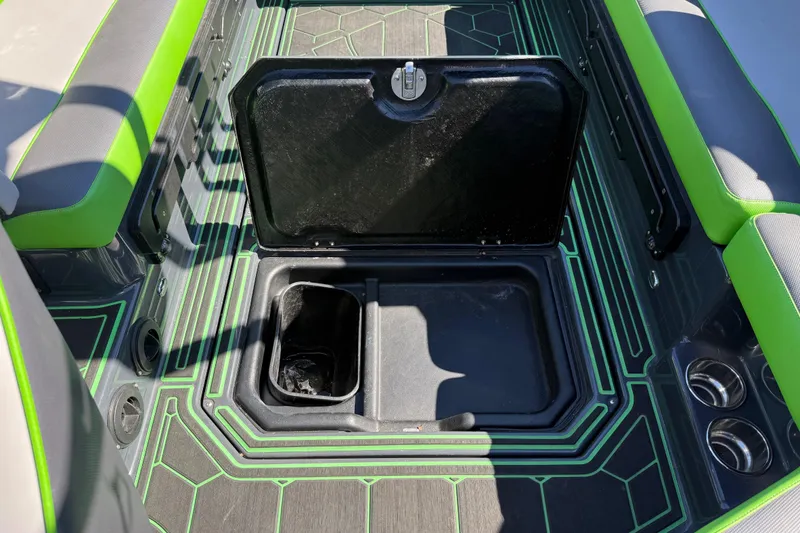 Slide: The Image of 2022 Moomba Makai boat interior with open storage compartment and vibrant green accents. - 11