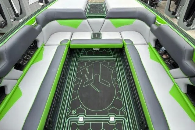 Slide: The Image of 2022 Moomba Makai boat interior with green and gray seating and custom flooring design. - 12