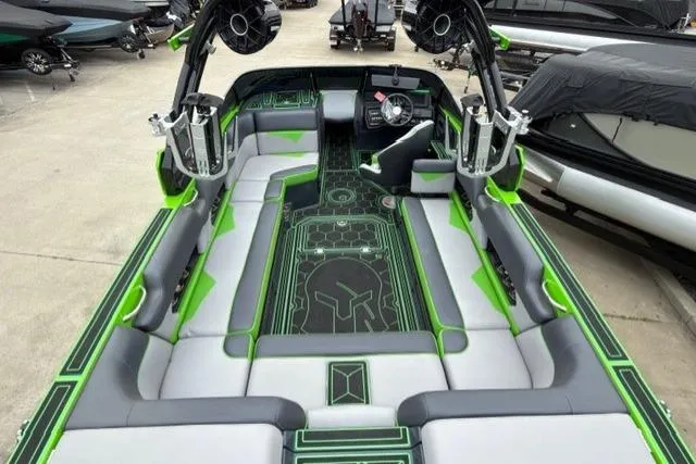 Slide: The Image of 2022 Moomba Makai boat interior with green and gray seating, advanced dashboard, and speaker system. - 17