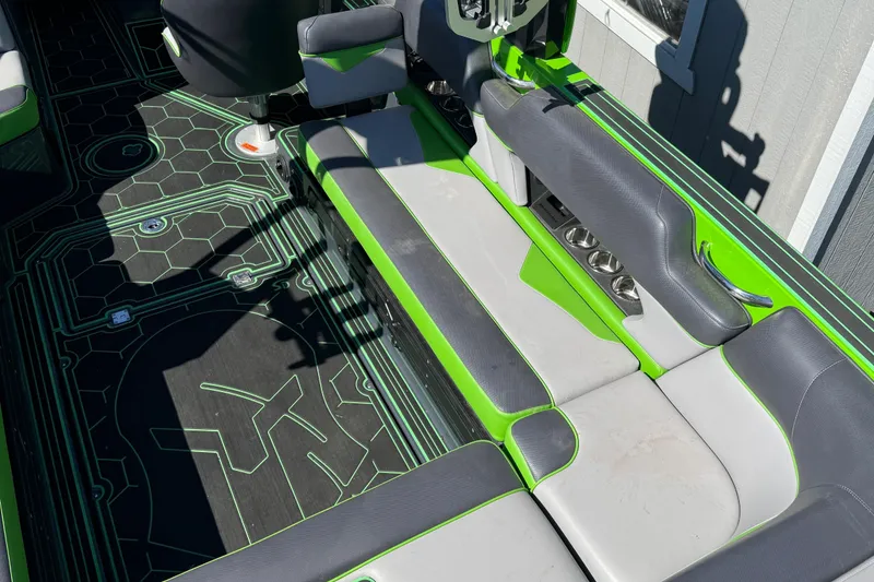 Slide: The Image of 2022 Moomba Makai boat interior with green and gray seating and geometric floor design. - 22