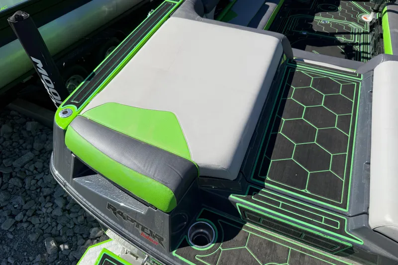 Slide: The Image of 2022 Moomba Makai boat interior with green and gray seating and hexagonal pattern flooring. - 23