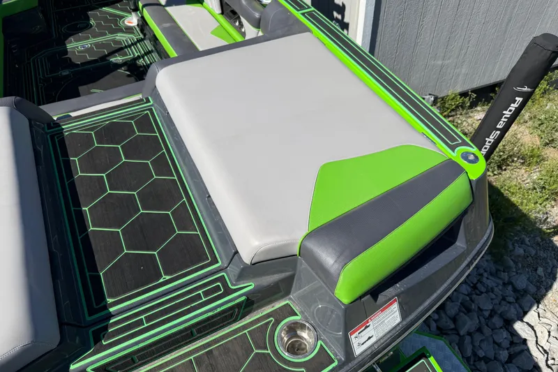Slide: The Image of 2022 Moomba Makai boat interior with green and gray seating and hexagonal pattern flooring. - 24