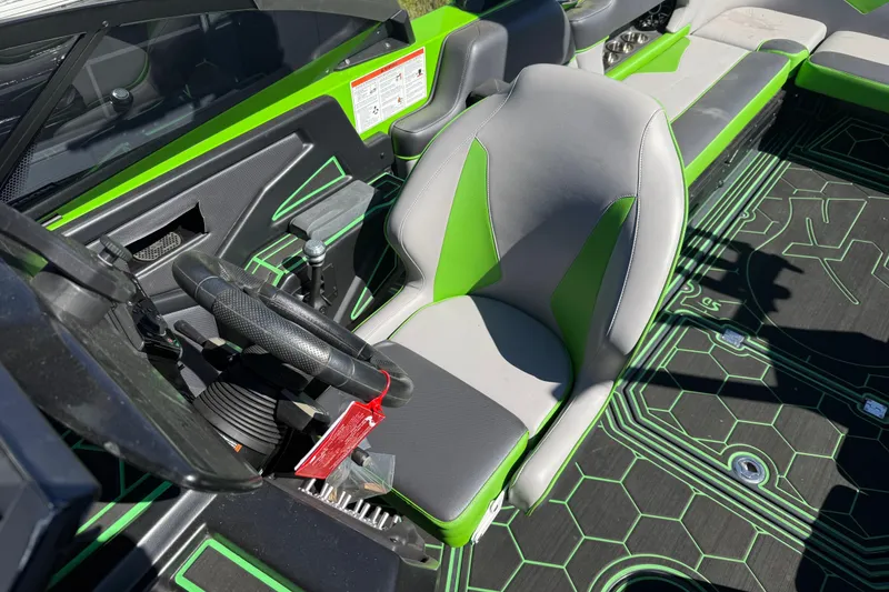 Slide: The Image of 2022 Moomba Makai boat interior with green and gray seating and steering wheel. - 5