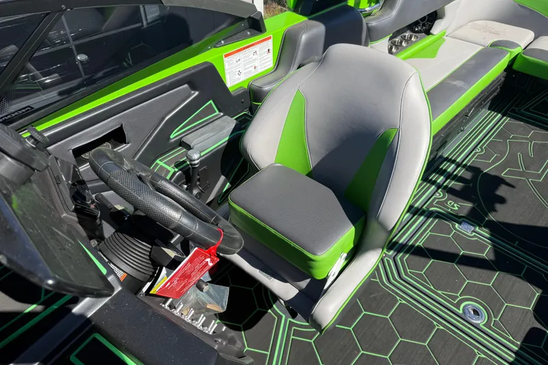 Slide: The Image of 2022 Moomba Makai boat interior with green and gray seating and steering wheel. - 6