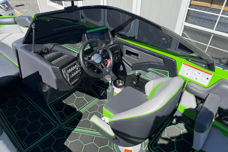Slide: The Image of 2022 Moomba Makai boat interior with green accents and modern dashboard controls. - 8