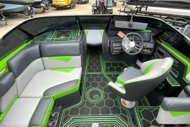 Slide: The Image of 2022 Moomba Makai boat interior with green and gray seating, modern dashboard, and geometric flooring. - 9