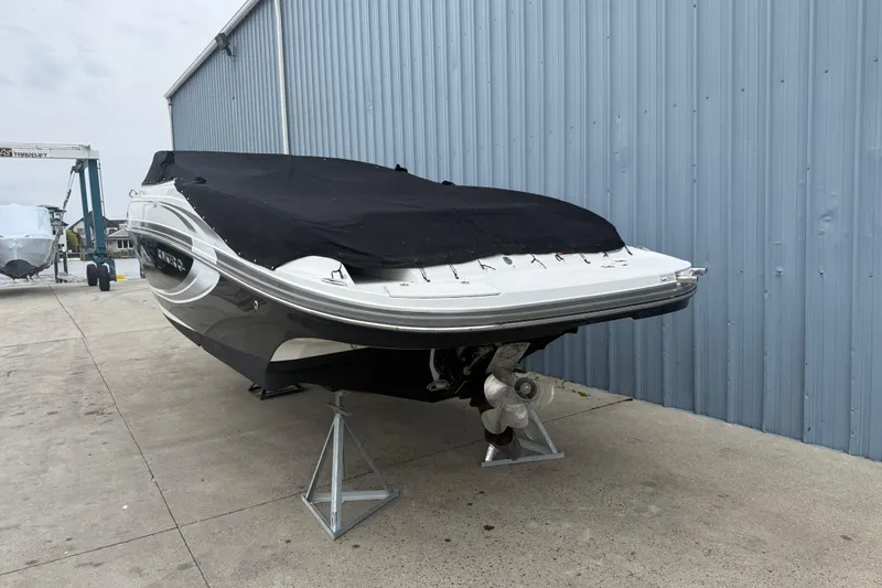 The Image of 2013 Rinker 246 Captiva Cuddy boat on display in a marina setting. - 0