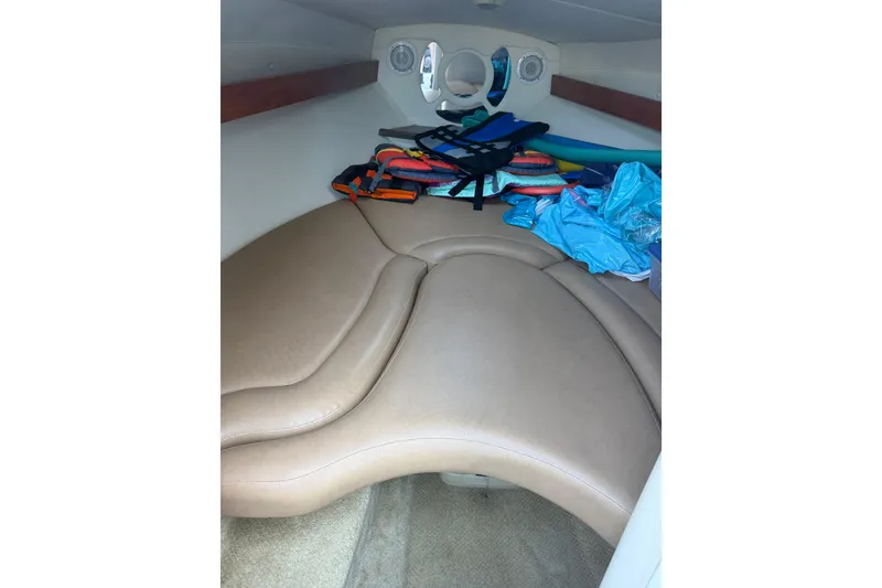 Slide: The Image of 2013 Rinker 246 Captiva Cuddy cabin interior with life jackets and gear. - 10