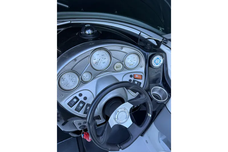Slide: The Image of Dashboard of a 2013 Rinker 246 Captiva Cuddy boat with gauges and steering wheel. - 11