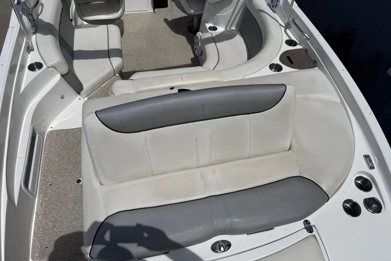 Slide: The Image of 2013 Rinker 246 Captiva Cuddy boat interior with white and gray seating. - 13