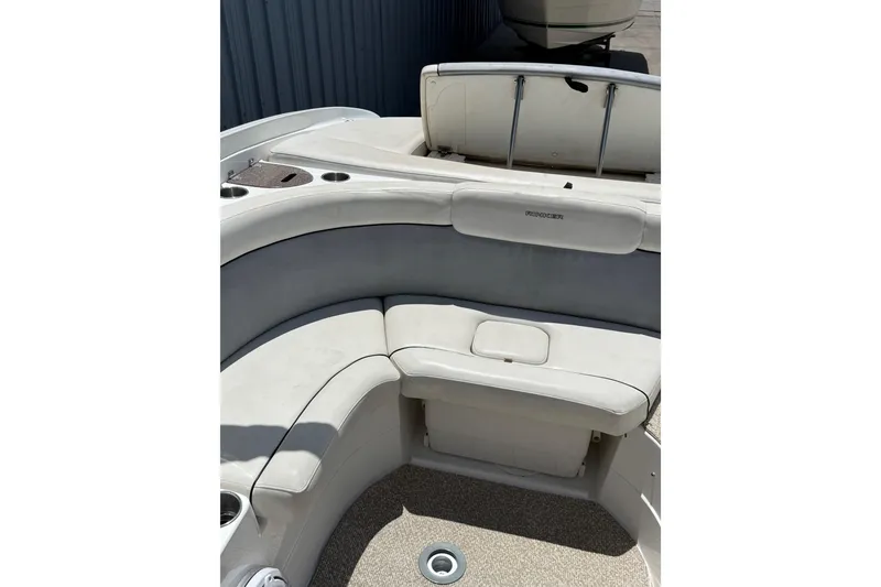 Slide: The Image of 2013 Rinker 246 Captiva Cuddy boat interior with cushioned seating and storage. - 16