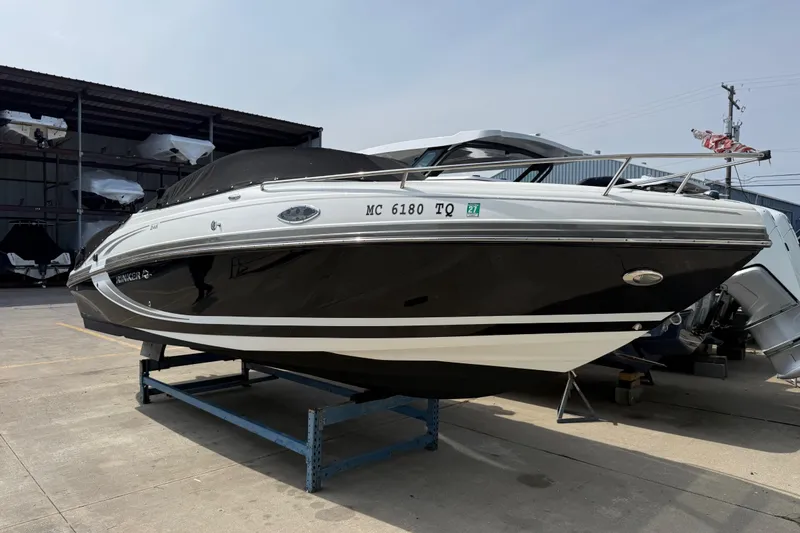 Slide: The Image of 2013 Rinker 246 Captiva Cuddy boat on display in a marina setting. - 5
