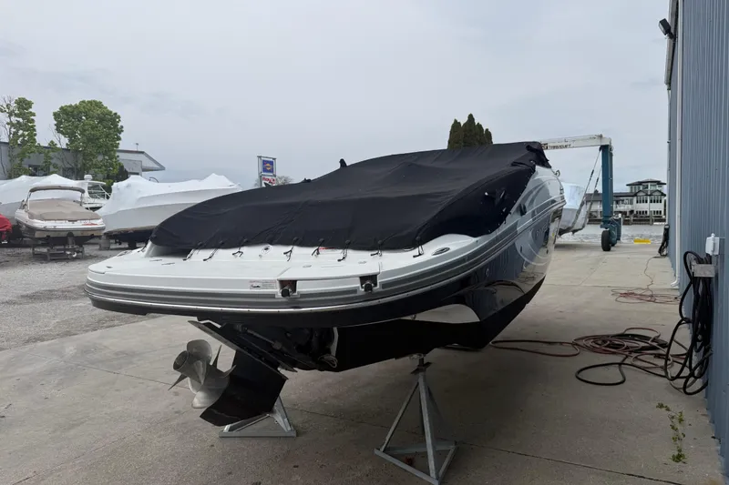Slide: The Image of 2013 Rinker 246 Captiva Cuddy boat covered and elevated on stands in a marina. - 9