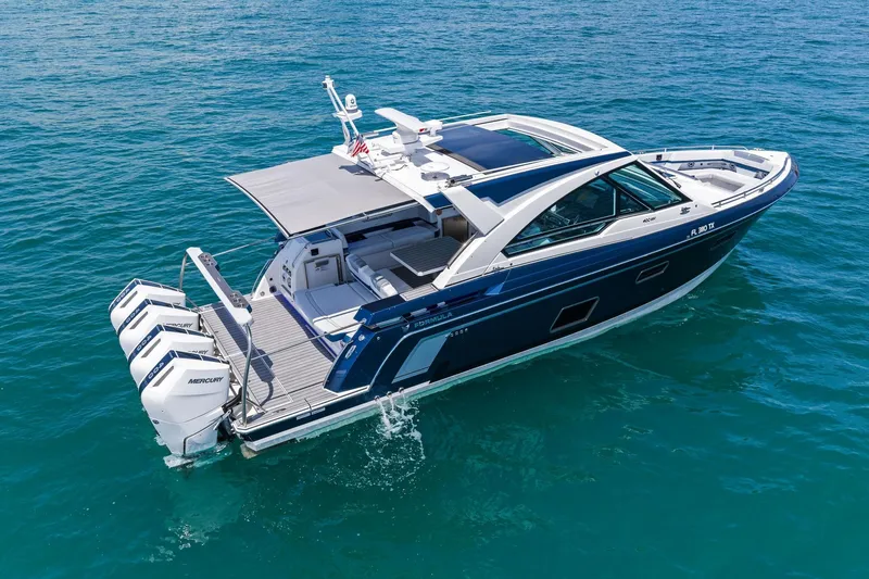 Slide: The Image of 2025 Formula 400 Super Sport Crossover boat cruising on clear blue water. - 12