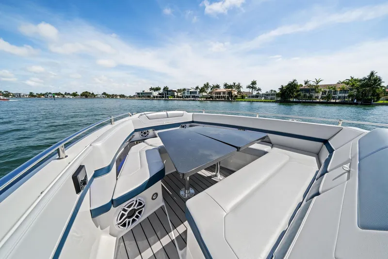 Slide: The Image of 2025 Formula 400 Super Sport Crossover boat interior with seating and table on a sunny day. - 14