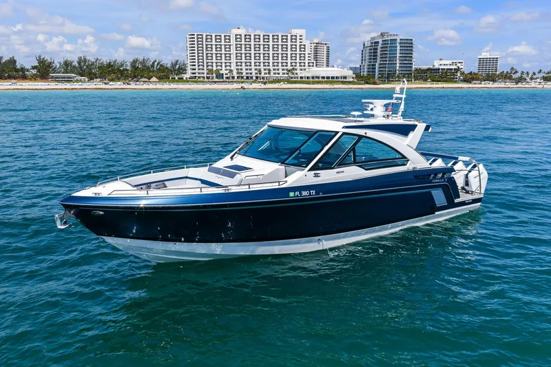 Slide: The Image of 2025 Formula 400 Super Sport Crossover yacht cruising near a coastal city skyline. - 2