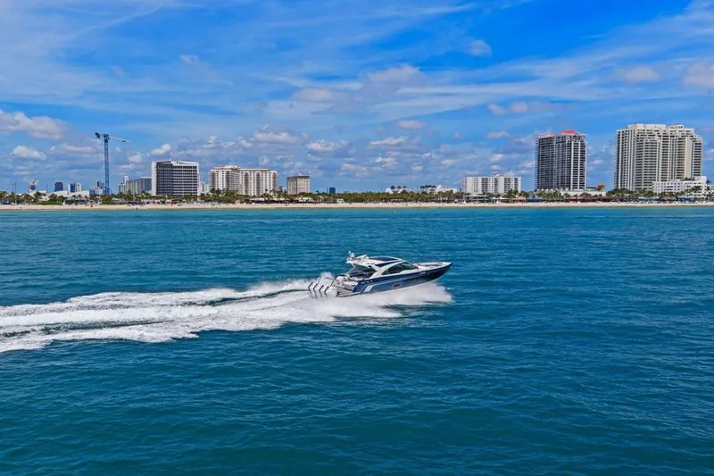 Slide: The Image of 2025 Formula 400 Super Sport Crossover cruising near a city skyline on a sunny day. - 63