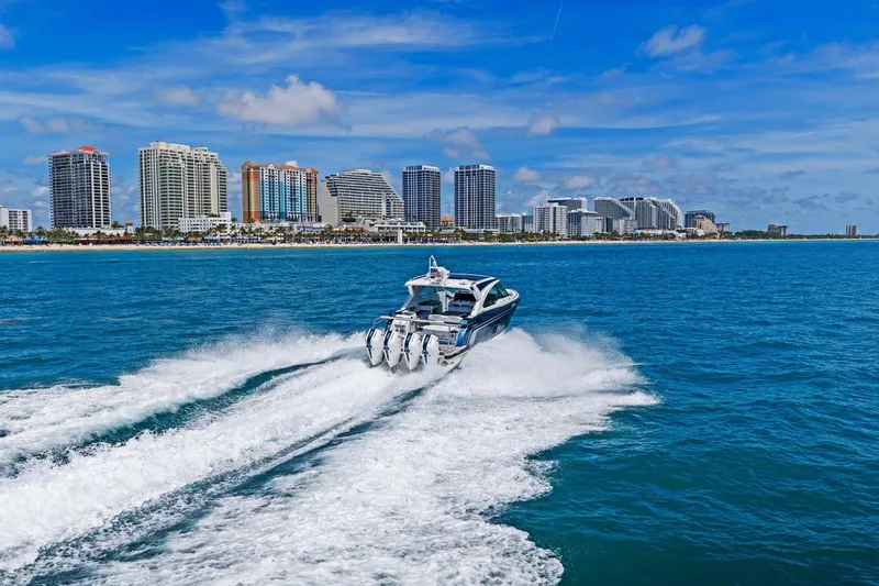 Slide: The Image of 2025 Formula 400 Super Sport Crossover cruising near a city skyline on a sunny day. - 64