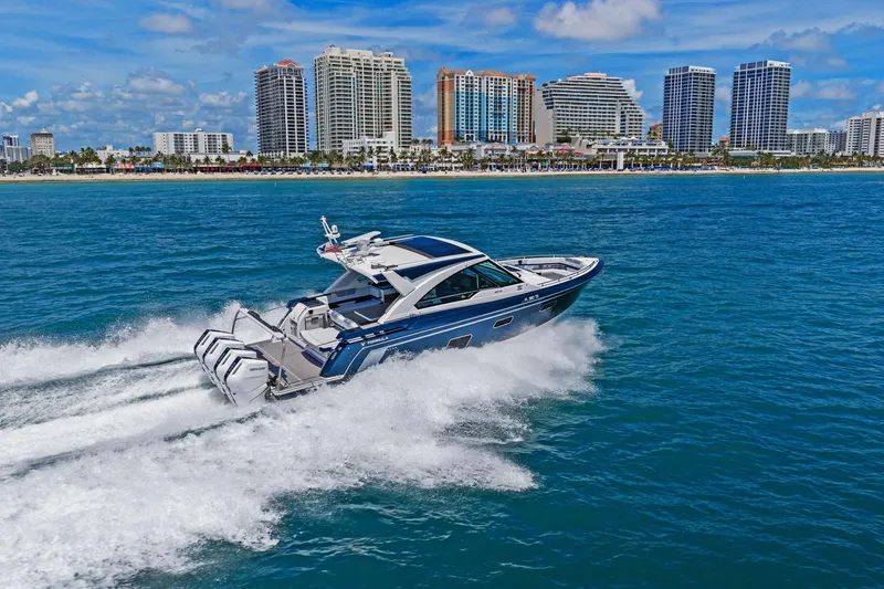 Slide: The Image of 2025 Formula 400 Super Sport Crossover cruising near a city skyline on a sunny day. - 65