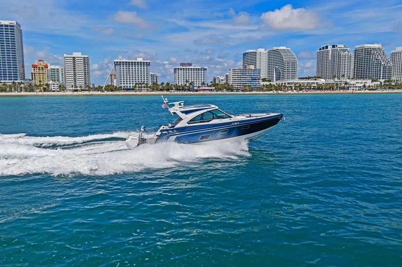 Slide: The Image of 2025 Formula 400 Super Sport Crossover cruising near city skyline on a sunny day. - 68
