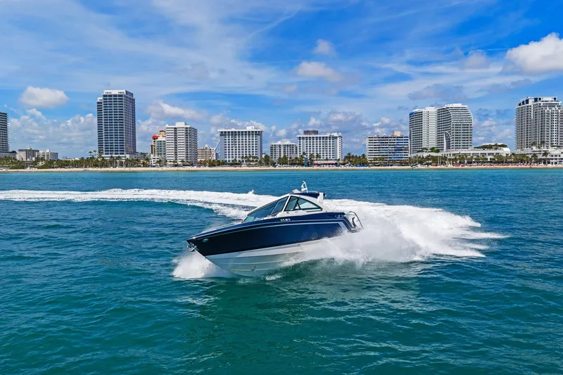 Slide: The Image of 2025 Formula 400 Super Sport Crossover cruising near city skyline on a sunny day. - 70