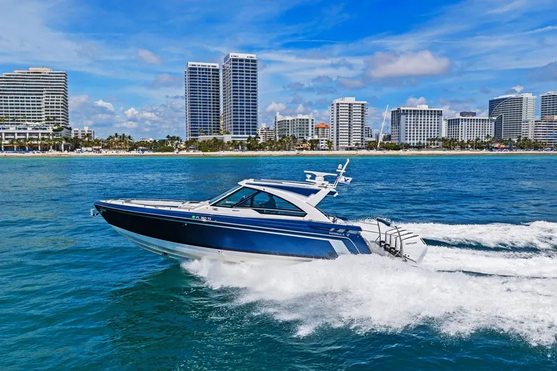 Slide: The Image of 2025 Formula 400 Super Sport Crossover cruising near a city skyline on a sunny day. - 75