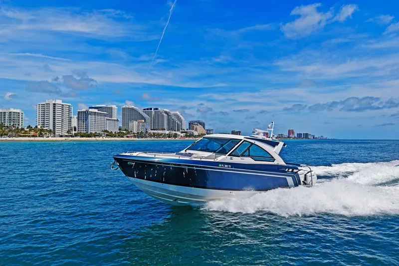 Slide: The Image of 2025 Formula 400 Super Sport Crossover cruising near a coastal city skyline. - 76