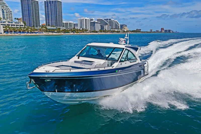 Slide: The Image of 2025 Formula 400 Super Sport Crossover cruising near a coastal city skyline. - 77