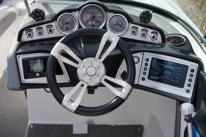 Slide: The Image of 2016 MasterCraft X10 boat dashboard with steering wheel and digital display. - 12