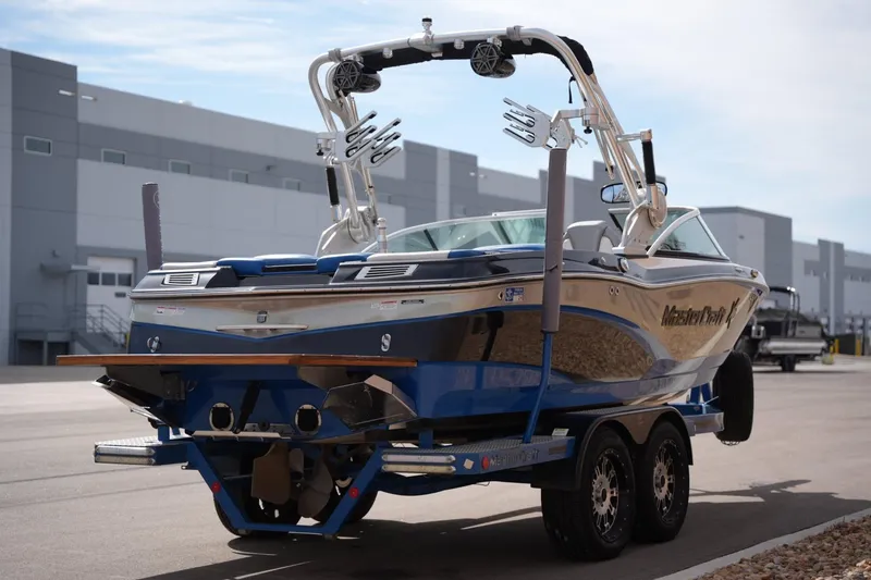 Slide: The Image of 2016 MasterCraft X10 boat on trailer, parked outdoors near industrial buildings. - 4