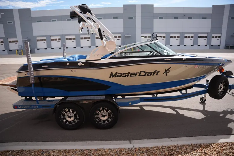Slide: The Image of 2016 MasterCraft X10 boat on trailer, parked in industrial area. - 5