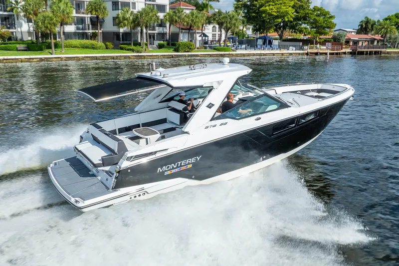 Slide: The Image of 2022 Monterey 378SS Super Sport boat cruising on a scenic waterway. - 2