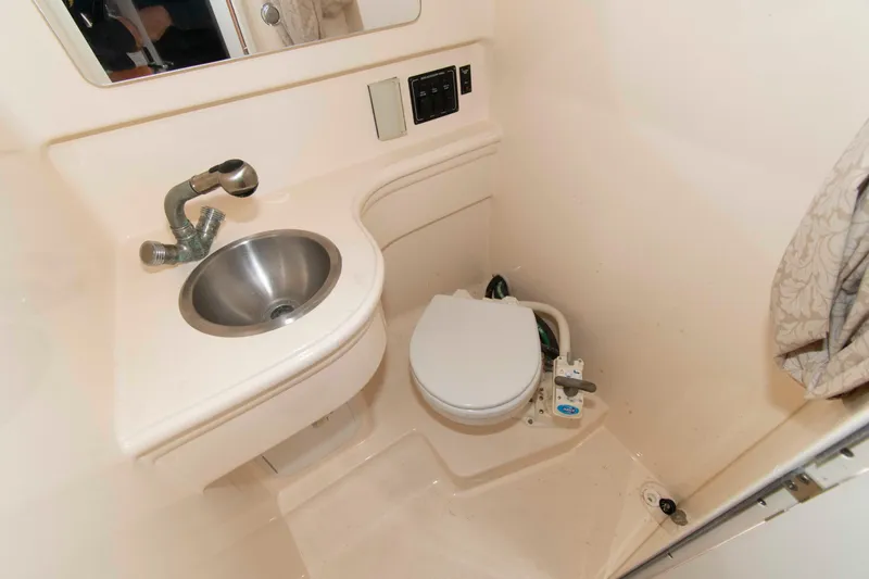 Slide: The Image of 2006 Larson Cabrio 240 boat bathroom with sink and toilet. - 12