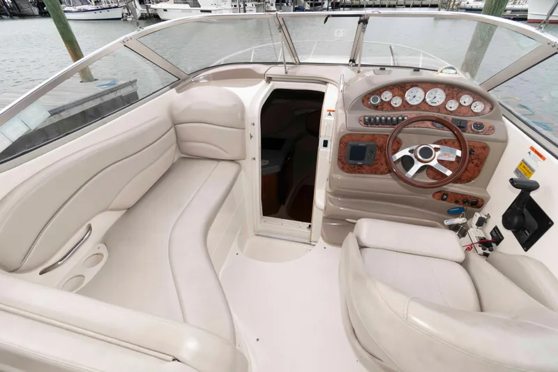Slide: The Image of 2006 Larson Cabrio 240 boat interior with steering wheel, dashboard, and seating area. - 3