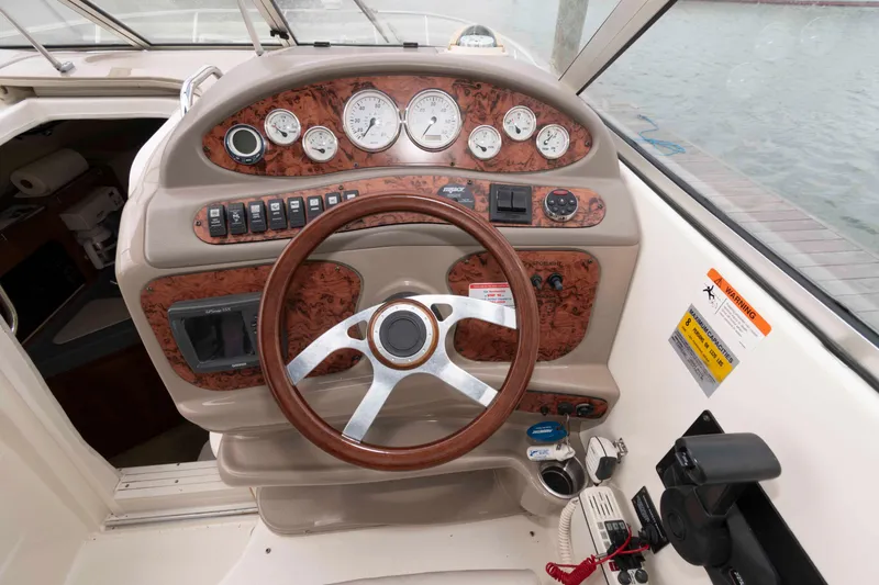 Slide: The Image of 2006 Larson Cabrio 240 boat dashboard with wood accents and steering wheel. - 5