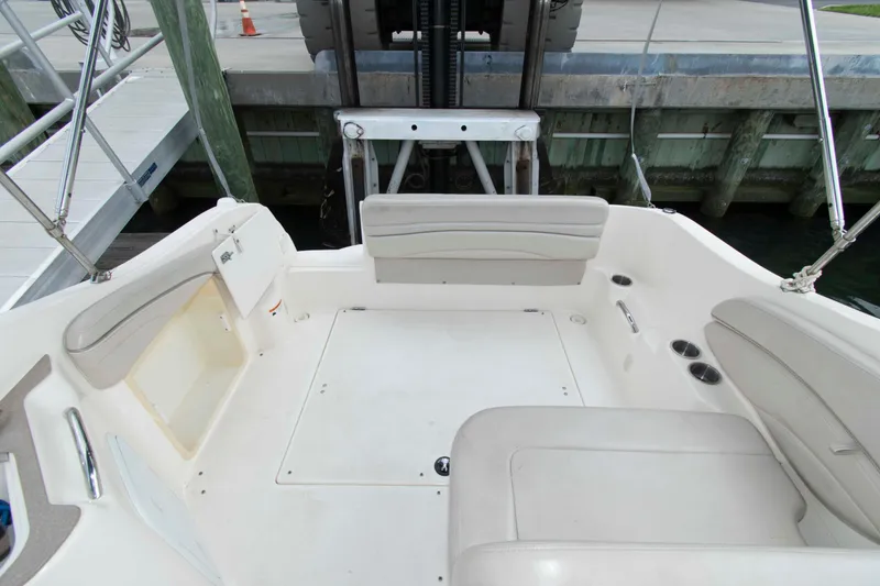 Slide: The Image of 2006 Larson Cabrio 240 boat interior with white seating and dock view. - 7