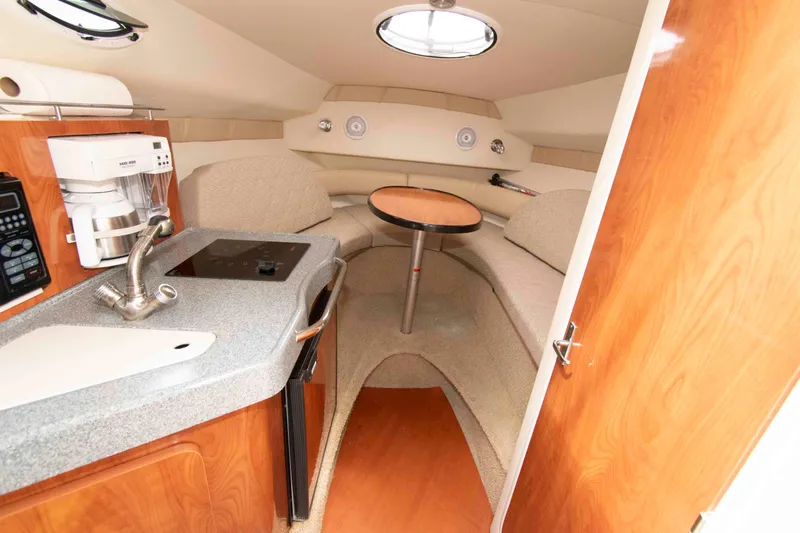 Slide: The Image of Interior of 2006 Larson Cabrio 240 boat with kitchenette and seating area. - 8