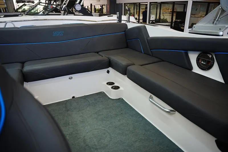 Slide: The Image of 2019 MasterCraft NXT22 boat interior with black seating and blue accents. - 11