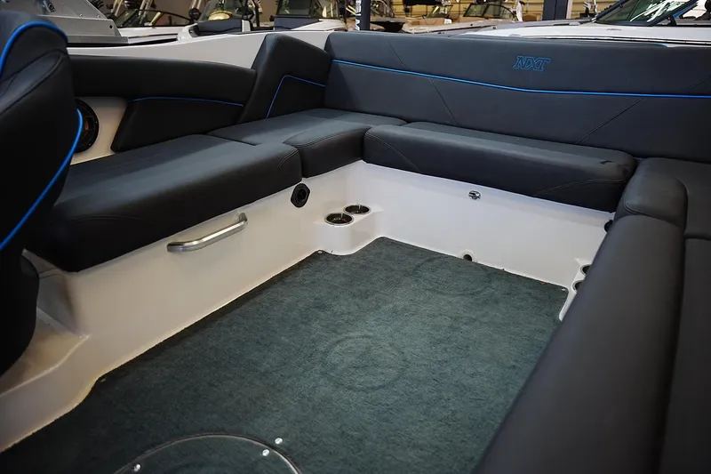 Slide: The Image of Interior of 2019 MasterCraft NXT22 boat with black seating and blue accents. - 12