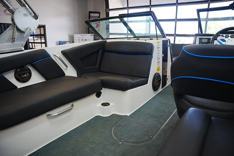 Slide: The Image of 2019 MasterCraft NXT22 boat interior with black seating and blue accents. - 14